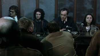 Movie still from “Bloody Sunday” (2002), directed by Paul Greengrass – A group of people sitting around a table; Medium shot, Over the shoulder angle