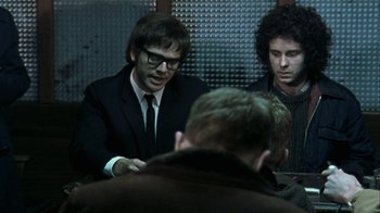 Movie still from “Bloody Sunday” (2002), directed by Paul Greengrass – A group of men sitting in a room talking to each other; Medium shot, Over the shoulder angle
