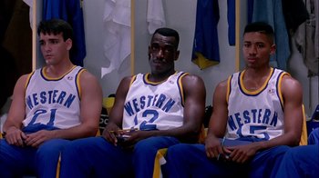 Movie still from “Blue Chips” (1994), directed by William Friedkin – A group of men sitting next to each other in a locker room; Medium shot, High angle