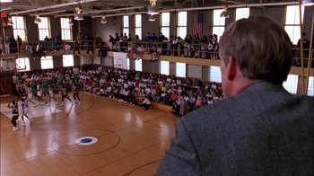 Movie still from “Blue Chips” (1994), directed by William Friedkin – A crowd of people watching a basketball game in a gym; Extreme Wide shot, High angle