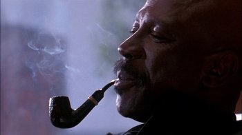 Movie still from “Blue Chips” (1994), directed by William Friedkin – A person with a pipe in his mouth; Close Up shot, Low angle