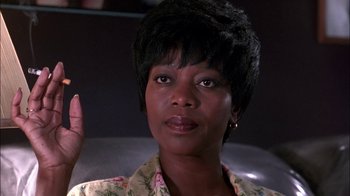 Movie still from “Blue Chips” (1994), directed by William Friedkin – A person sitting in a chair; Close Up shot, Low angle