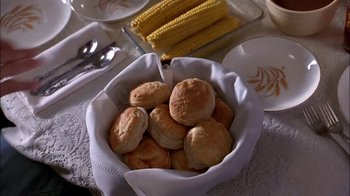 Movie still from “Blue Chips” (1994), directed by William Friedkin – A bowl filled with biscuits on top of a table next to corn; Extreme Close Up shot, High angle