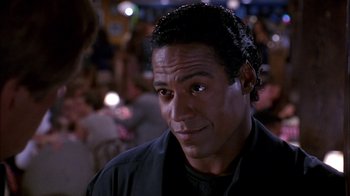 Movie still from “Blue Chips” (1994), directed by William Friedkin – A person wearing a black shirt; Close Up shot, Over the shoulder angle