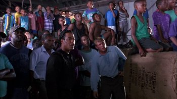 Movie still from “Blue Chips” (1994), directed by William Friedkin – A group of men standing next to each other in a room; Wide shot, High angle