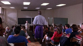 Movie still from “Blue Chips” (1994), directed by William Friedkin – A group of people sitting in a room; Wide shot, Low angle