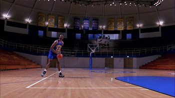 Movie still from “Blue Chips” (1994), directed by William Friedkin – A man in a blue shirt is playing a game of basketball; Extreme Wide shot, High angle