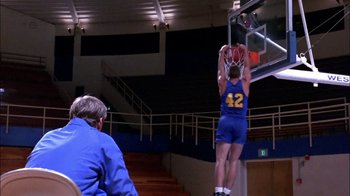 Movie still from “Blue Chips” (1994), directed by William Friedkin – A man in a blue and yellow basketball uniform dunking a basketball; Wide shot, Low angle