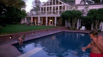 Movie still from “Blue Chips” (1994), directed by William Friedkin – A large swimming pool in front of a large house; Extreme Wide shot, High angle