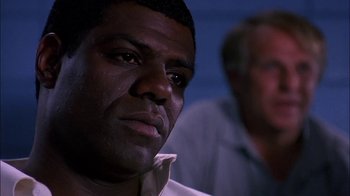 Movie still from “Blue Chips” (1994), directed by William Friedkin – A man's face in front of another man; Close Up shot, Low angle