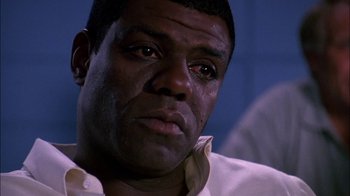 Movie still from “Blue Chips” (1994), directed by William Friedkin – A man's face in a white shirt; Close Up shot, Low angle