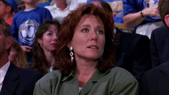 Movie still from “Blue Chips” (1994), directed by William Friedkin – A person sitting in front of a group of people; Close Up shot, Low angle