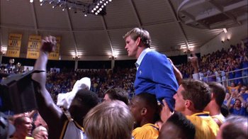Movie still from “Blue Chips” (1994), directed by William Friedkin – A crowd of people watching a basketball game in a stadium; Medium shot, Low angle