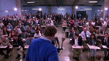 Movie still from “Blue Chips” (1994), directed by William Friedkin – A crowd of people sitting and standing in a room; Wide shot, High angle