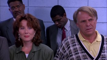Movie still from “Blue Chips” (1994), directed by William Friedkin – A group of people standing next to each other in front of a brick wall; Medium shot, Low angle