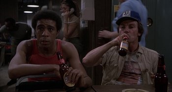 Movie still from “Blue Collar” (1978), directed by Paul Schrader – Two men sitting at a table drinking beers; Medium shot, High angle