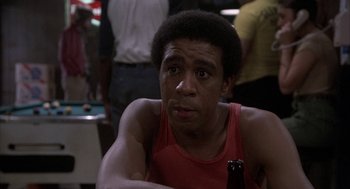 Movie still from “Blue Collar” (1978), directed by Paul Schrader – A person holding a bottle of beer; Close Up shot, Over the shoulder angle