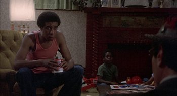 Movie still from “Blue Collar” (1978), directed by Paul Schrader – Two young men sitting in front of a fire place; Medium shot, Low angle