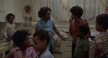 Movie still from “Blue Collar” (1978), directed by Paul Schrader – A group of people standing around a kitchen sink; Medium shot, High angle