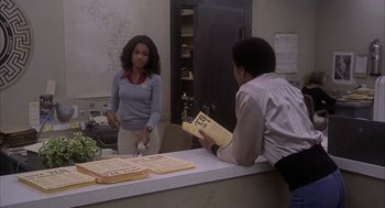 Movie still from “Blue Collar” (1978), directed by Paul Schrader – A man and a woman standing at a counter in a room; Medium shot, Over the shoulder angle