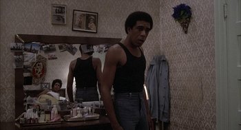 Movie still from “Blue Collar” (1978), directed by Paul Schrader – A young man standing in front of a bathroom mirror; Medium shot, Low angle