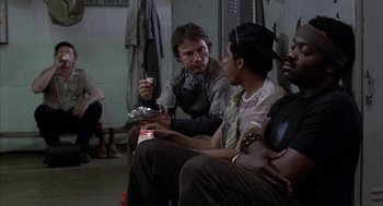 Movie still from “Blue Collar” (1978), directed by Paul Schrader – A group of men sitting around a room talking to each other; Medium shot, High angle