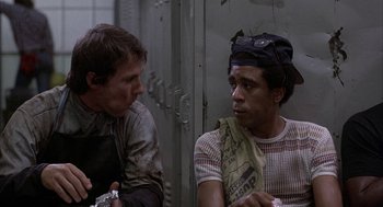 Movie still from “Blue Collar” (1978), directed by Paul Schrader – Two men sitting next to each other in a room; Medium shot, Over the shoulder angle