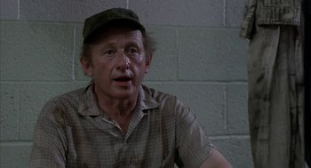 Movie still from “Blue Collar” (1978), directed by Paul Schrader – An older man wearing a hat and a plaid shirt; Close Up shot, Over the shoulder angle