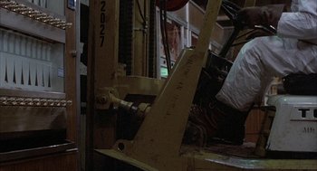 Movie still from “Blue Collar” (1978), directed by Paul Schrader – A fork lift in a warehouse; Wide shot, Low angle