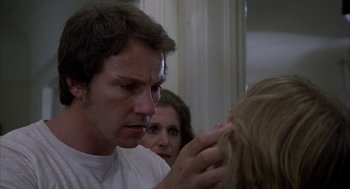 Movie still from “Blue Collar” (1978), directed by Paul Schrader – A man looking in the mirror while a woman looks at him; Close Up shot, Over the shoulder angle