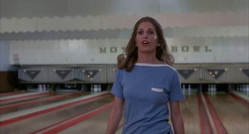 Movie still from “Blue Collar” (1978), directed by Paul Schrader – A woman standing in front of a bowling alley; Medium shot, Low angle