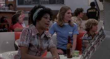 Movie still from “Blue Collar” (1978), directed by Paul Schrader – Two people sitting at a table with a beer; Medium shot, Over the shoulder angle