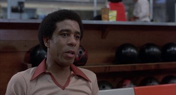 Movie still from “Blue Collar” (1978), directed by Paul Schrader – A man in a tan shirt is in a room with bowling balls; Close Up shot, Low angle