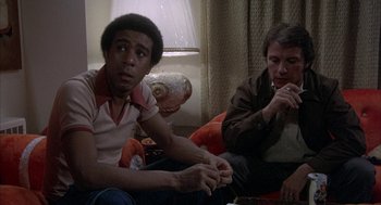 Movie still from “Blue Collar” (1978), directed by Paul Schrader – A group of people sitting in a living room next to each other; Medium shot, High angle