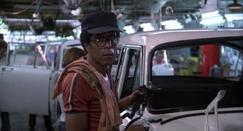 Movie still from “Blue Collar” (1978), directed by Paul Schrader – A man in a hat and glasses holding a car key; Medium shot, Low angle