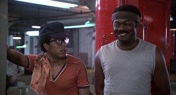 Movie still from “Blue Collar” (1978), directed by Paul Schrader – Two men are standing next to each other; Medium shot, Low angle