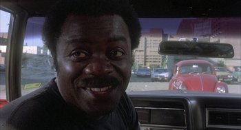 Movie still from “Blue Collar” (1978), directed by Paul Schrader – A person sitting in a car; Close Up shot, Over the shoulder angle