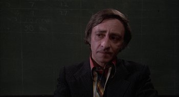 Movie still from “Blue Collar” (1978), directed by Paul Schrader – A man in a black suit and striped tie; Close Up shot, Low angle