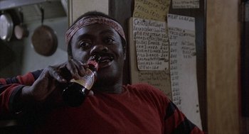 Movie still from “Blue Collar” (1978), directed by Paul Schrader – A man holding a bottle of beer in his mouth; Close Up shot, Low angle