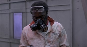 Movie still from “Blue Collar” (1978), directed by Paul Schrader – A man with a gas mask and goggles on; Medium shot, Low angle