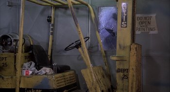 Movie still from “Blue Collar” (1978), directed by Paul Schrader – A forklift is parked in a room next to a window; Wide shot, Low angle