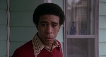 Movie still from “Blue Collar” (1978), directed by Paul Schrader – A young man in a red shirt is looking at the camera; Close Up shot, Low angle