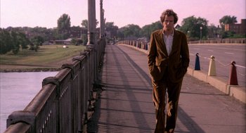 Movie still from “Blue Collar” (1978), directed by Paul Schrader – A man in a brown suit walking down a sidewalk; Wide shot, Low angle