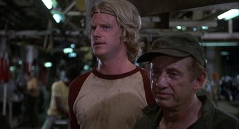 Movie still from “Blue Collar” (1978), directed by Paul Schrader – A man with blonde hair standing next to another man; Close Up shot, Low angle