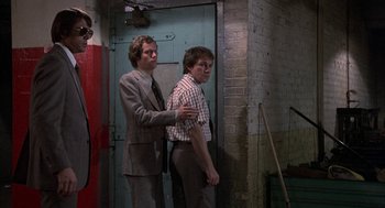 Movie still from “Blue Collar” (1978), directed by Paul Schrader – Two men standing next to each other near a wall; Medium shot, Over the shoulder angle