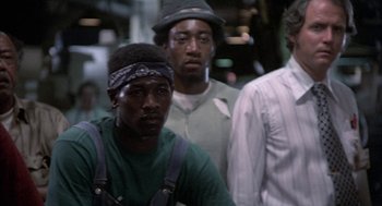 Movie still from “Blue Collar” (1978), directed by Paul Schrader – A group of men standing next to each other; Medium shot, Low angle