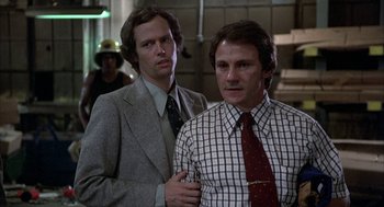 Movie still from “Blue Collar” (1978), directed by Paul Schrader – Two men standing next to each other wearing suits and ties; Medium shot, Low angle