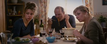 Movie still from “Blue Is the Warmest Colour” (2013), directed by Abdellatif Kechiche – Three people sitting at a dinner table eating spaghetti; Medium shot, Over the shoulder angle