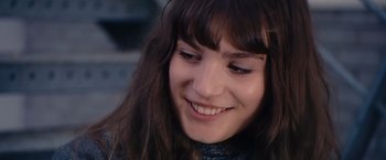 Movie still from “Blue Is the Warmest Colour” (2013), directed by Abdellatif Kechiche – A person with a smile on their face; Close Up shot, Over the shoulder angle