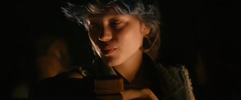 A woman with blue hair is holding something